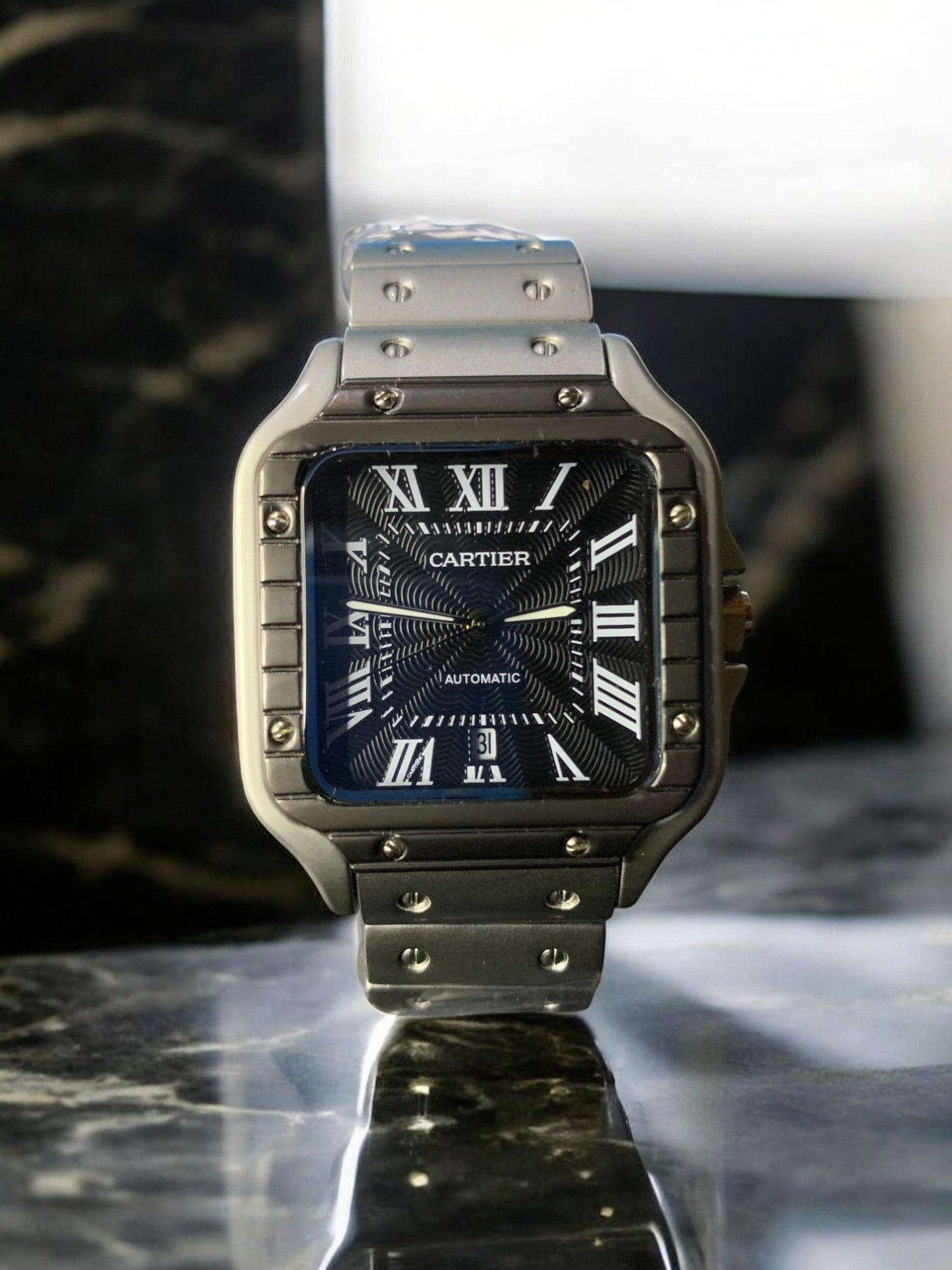 Cartier luxury watch with a sleek silver stainless steel case and bracelet, dark patterned dial, and Roman numeral markers. This automatic, 'old money' style timepiece exudes timeless elegance, perfect for luxury watch collectors and enthusiasts